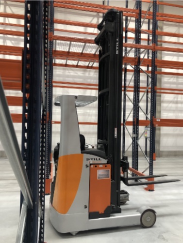 High-reach truck by the racking